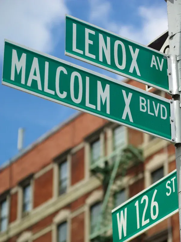 Panneaux de rue au croisement de Malcolm X Boulevard et de Lenox Avenue, à Harlem.
