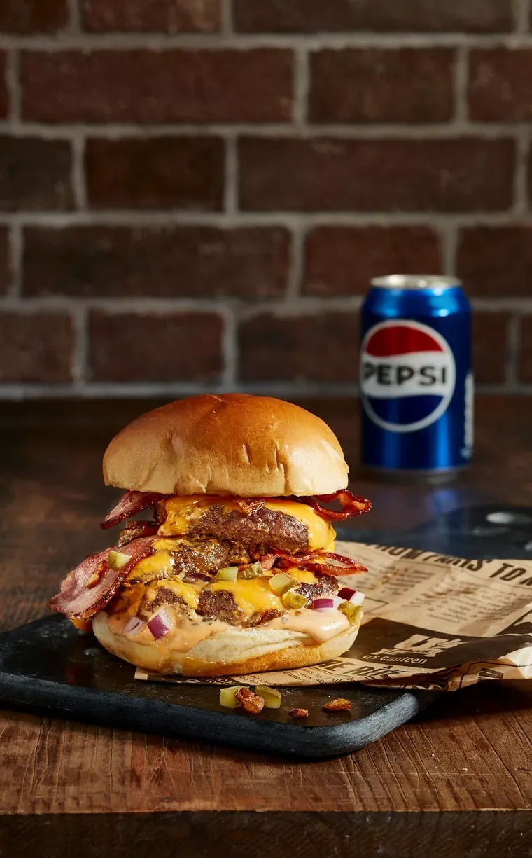 Burger triple au bacon croustillant, cheddar fondu et oignons rouges