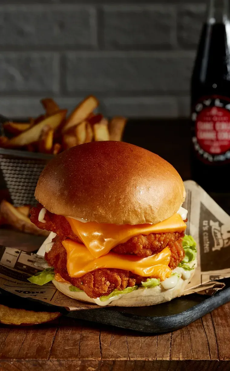 Burger à deux filets de poulet pané, cheddar fondu et salade